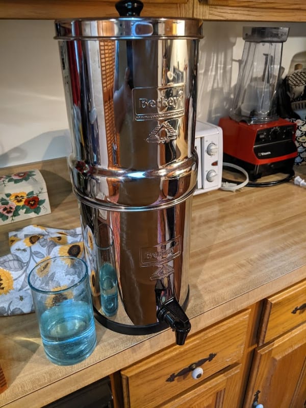Travel Berkey in use, glass of filtered water